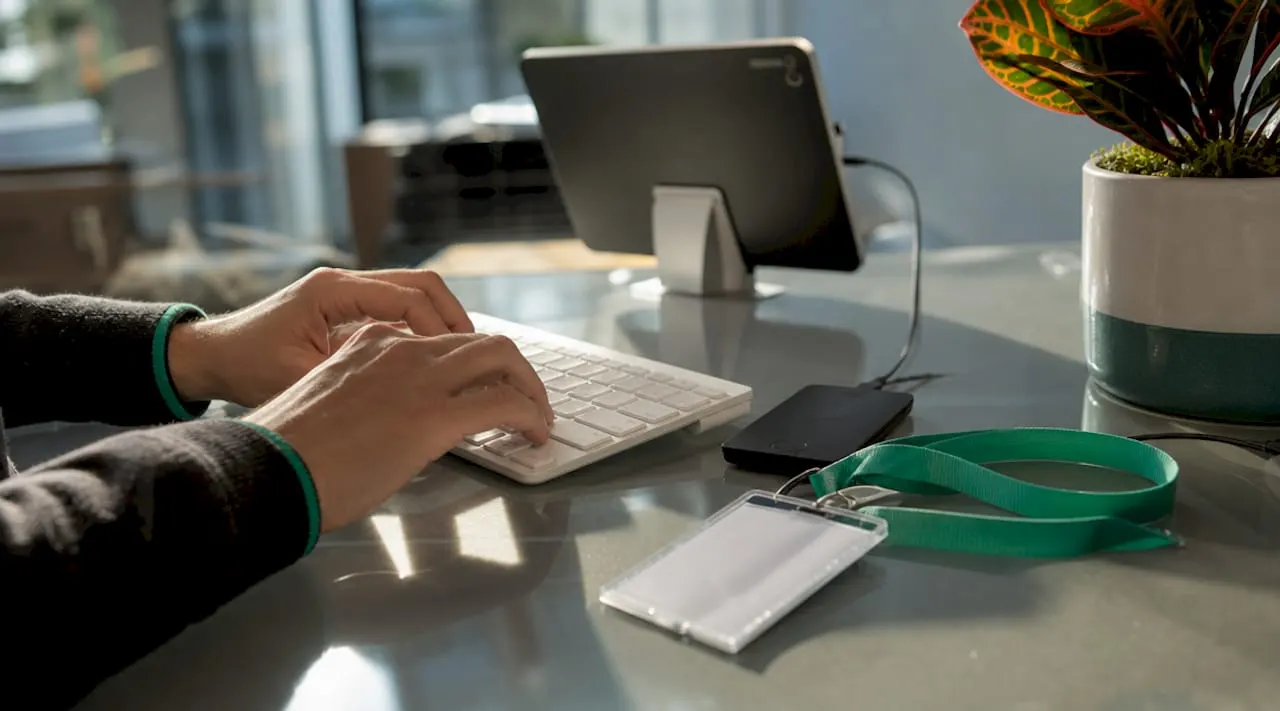 Hands typing with security devices on desk